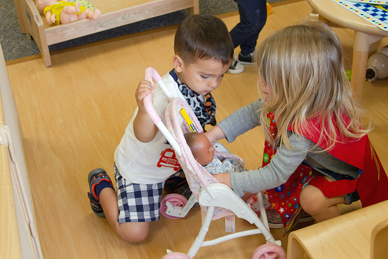 Children Playing With A Doll