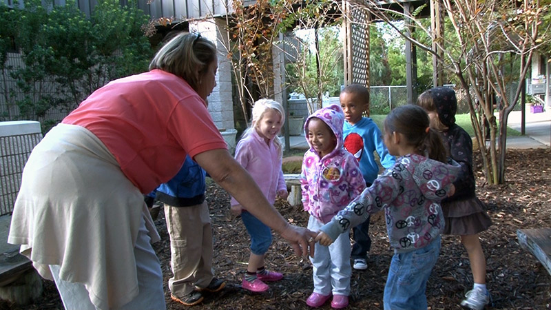 Caregiver playing with preschool children