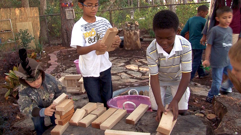Kids play outdoors with building blocks