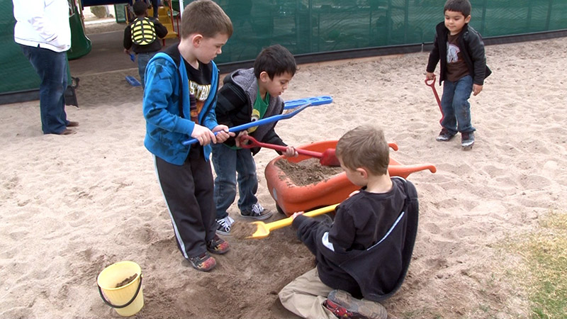 Preschool boys play with shovels