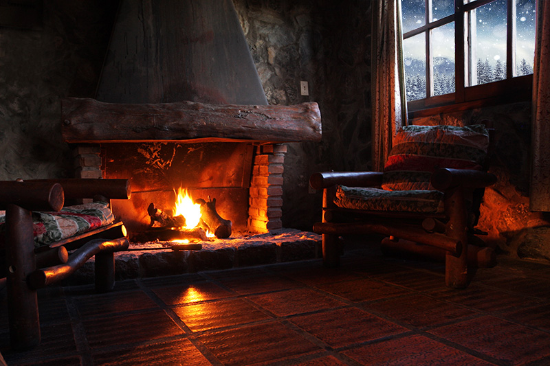 inside a cabin by a warm fire with snowy mountains outside the window