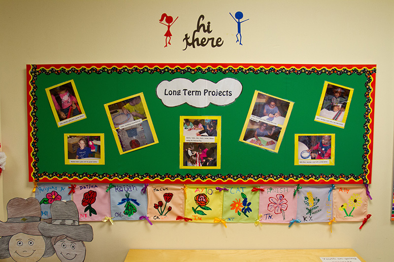 A bulletin board shows images from long term projects