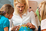 Teacher showing globe to preschool students