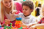 Child stacking blocks with teacher