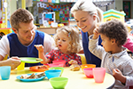 Teachers and children playing with a tea set