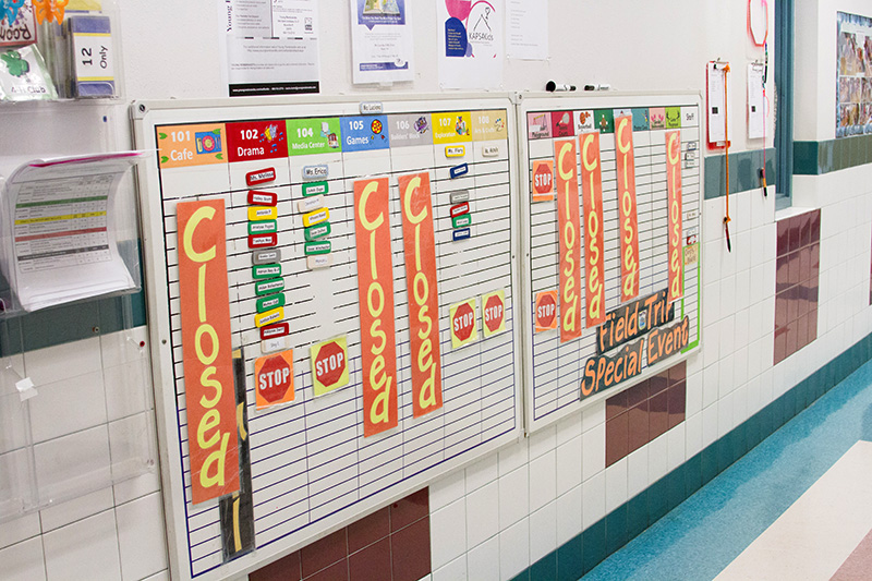 A chart on the wall visually depicts the schedule for each day of the week.